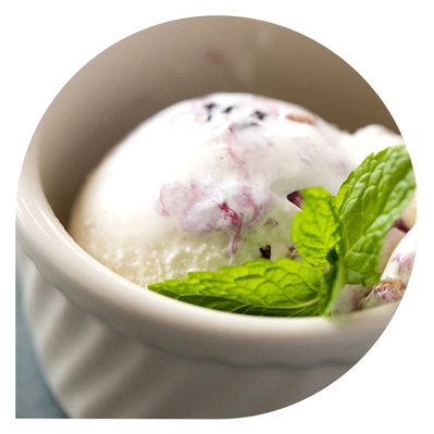 Scoops of creamy blueberry ice cream in a white bowl.